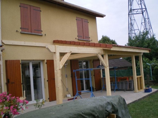 Véranda à ossature bois accolée à une maison