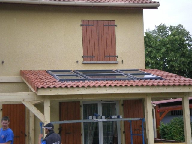 Toiture de tuiles avec fenêtres de toit au-dessus d'une véranda